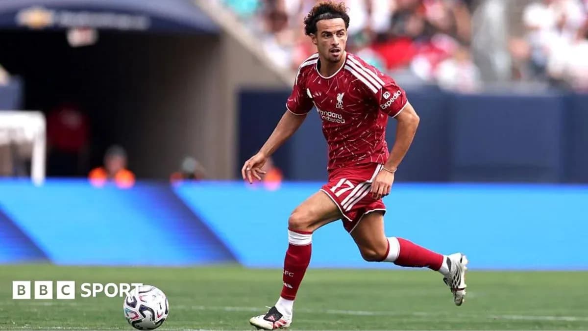 Player in red kit running with soccer ball Player in red kit running with soccer ball