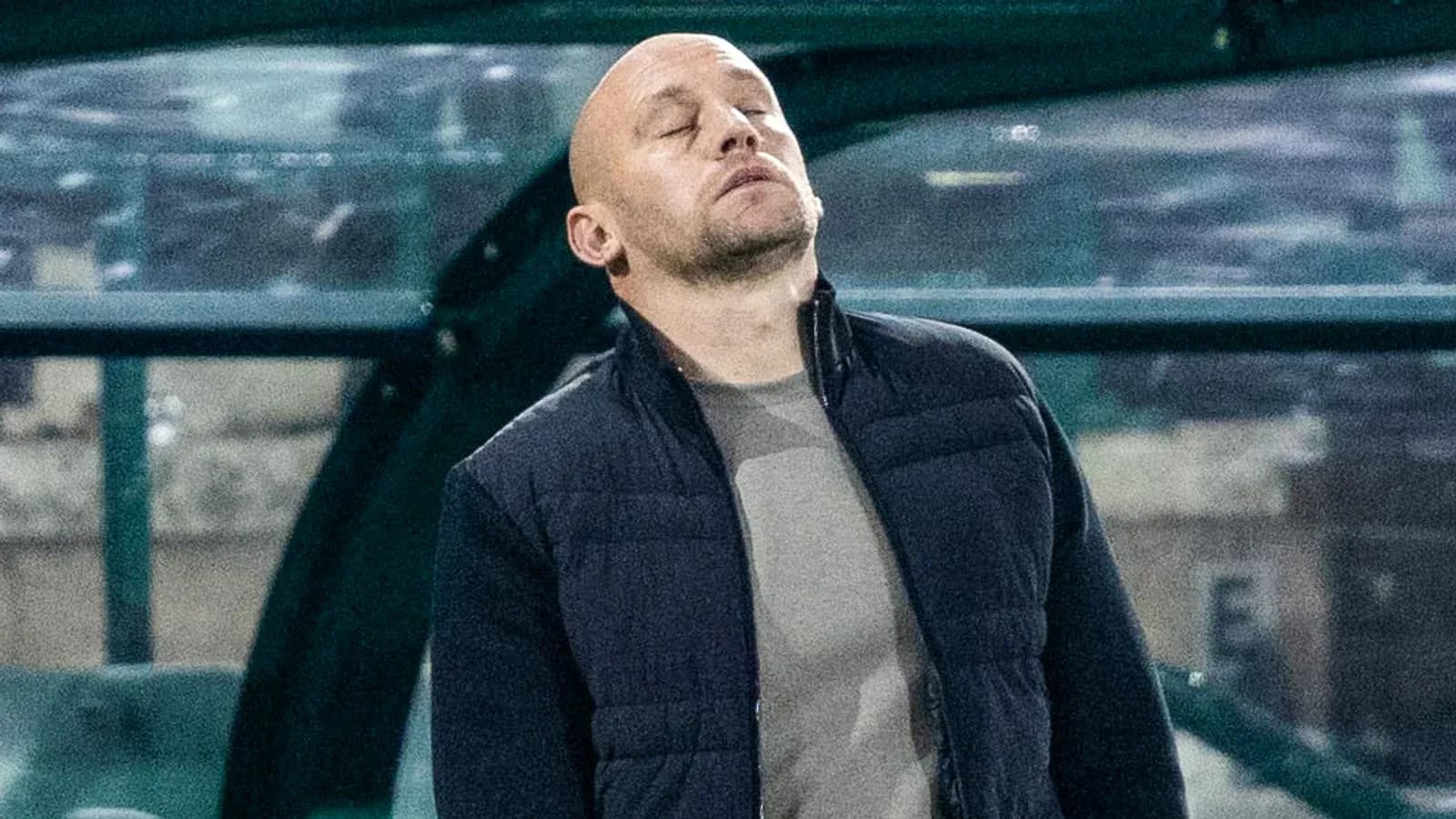 Coach with eyes closed on the sidelines Coach with eyes closed on the sidelines