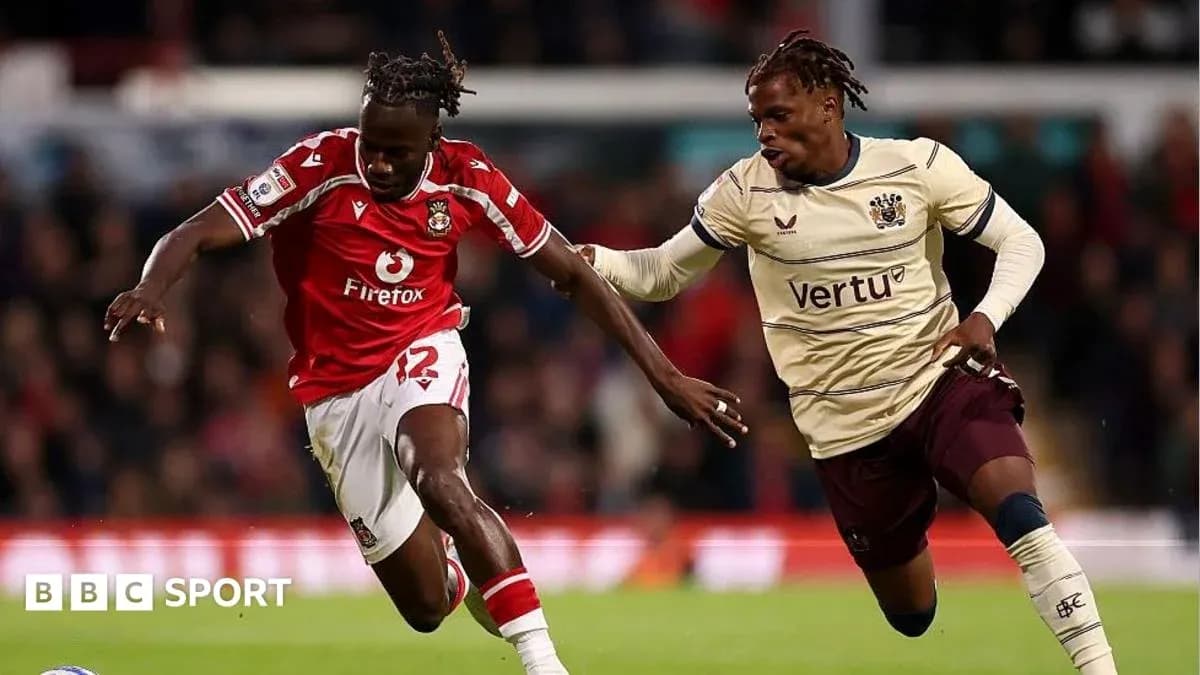 Player in red dribbling past opponent in beige jersey Player in red dribbling past opponent in beige jersey