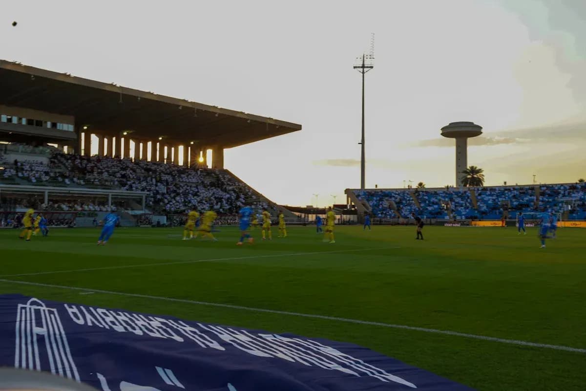 Players in blue and yellow competing on the pitch Players in blue and yellow competing on the pitch