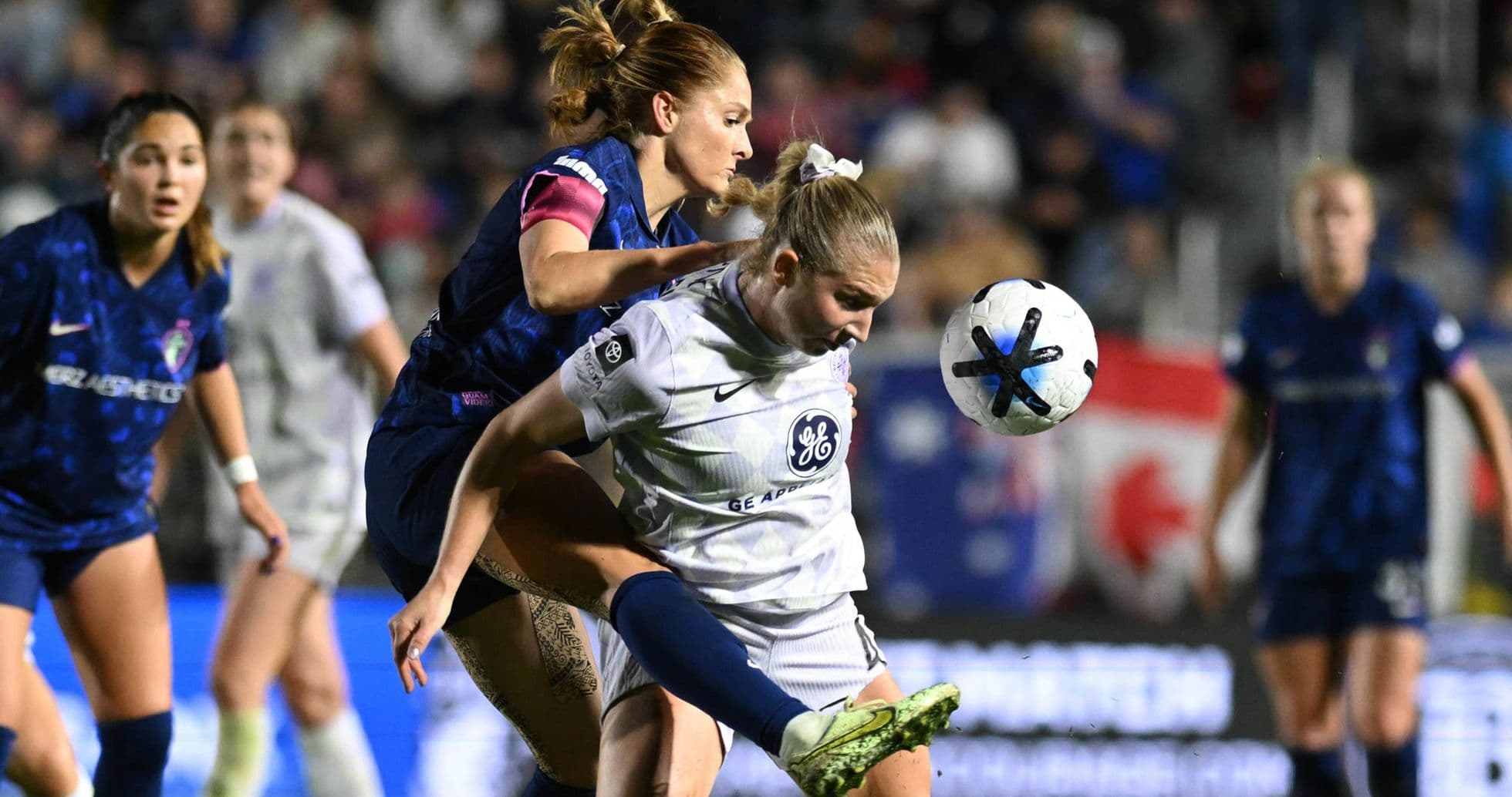 Players competing for the ball during NWSL match Players competing for the ball during NWSL match