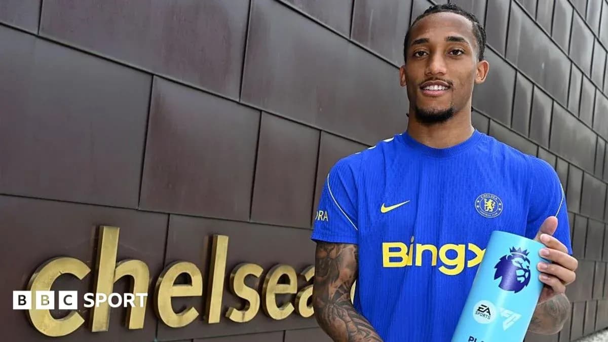 Player holding Premier League trophy outside Chelsea sign Player holding Premier League trophy outside Chelsea sign
