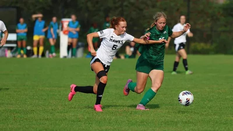 Player in white and green competing for soccer ball Player in white and green competing for soccer ball