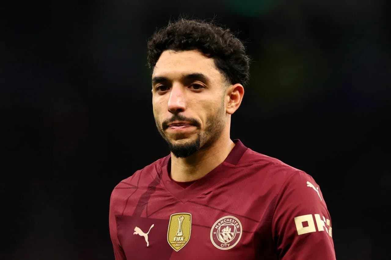 Player in maroon Manchester City jersey on field Player in maroon Manchester City jersey on field