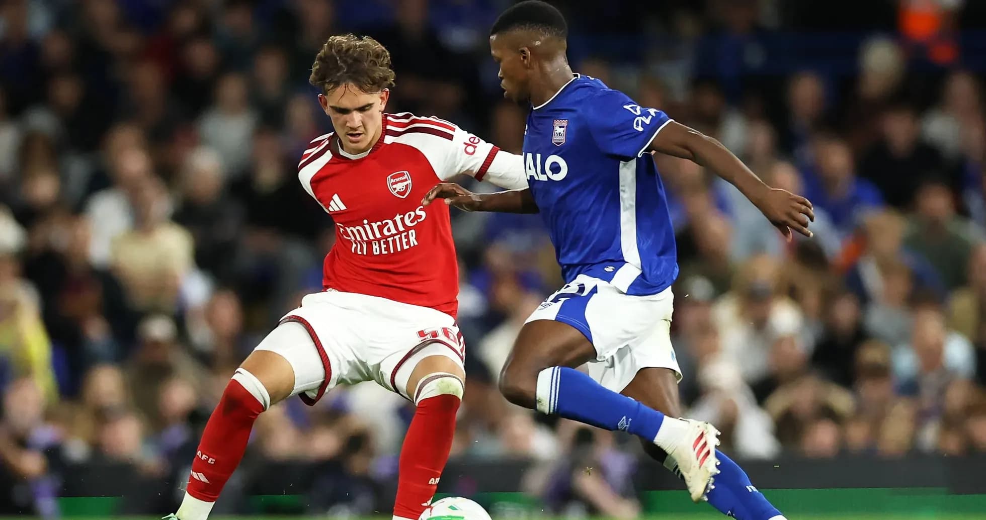 Arsenal player tackles opponent during match action Arsenal player tackles opponent during match action
