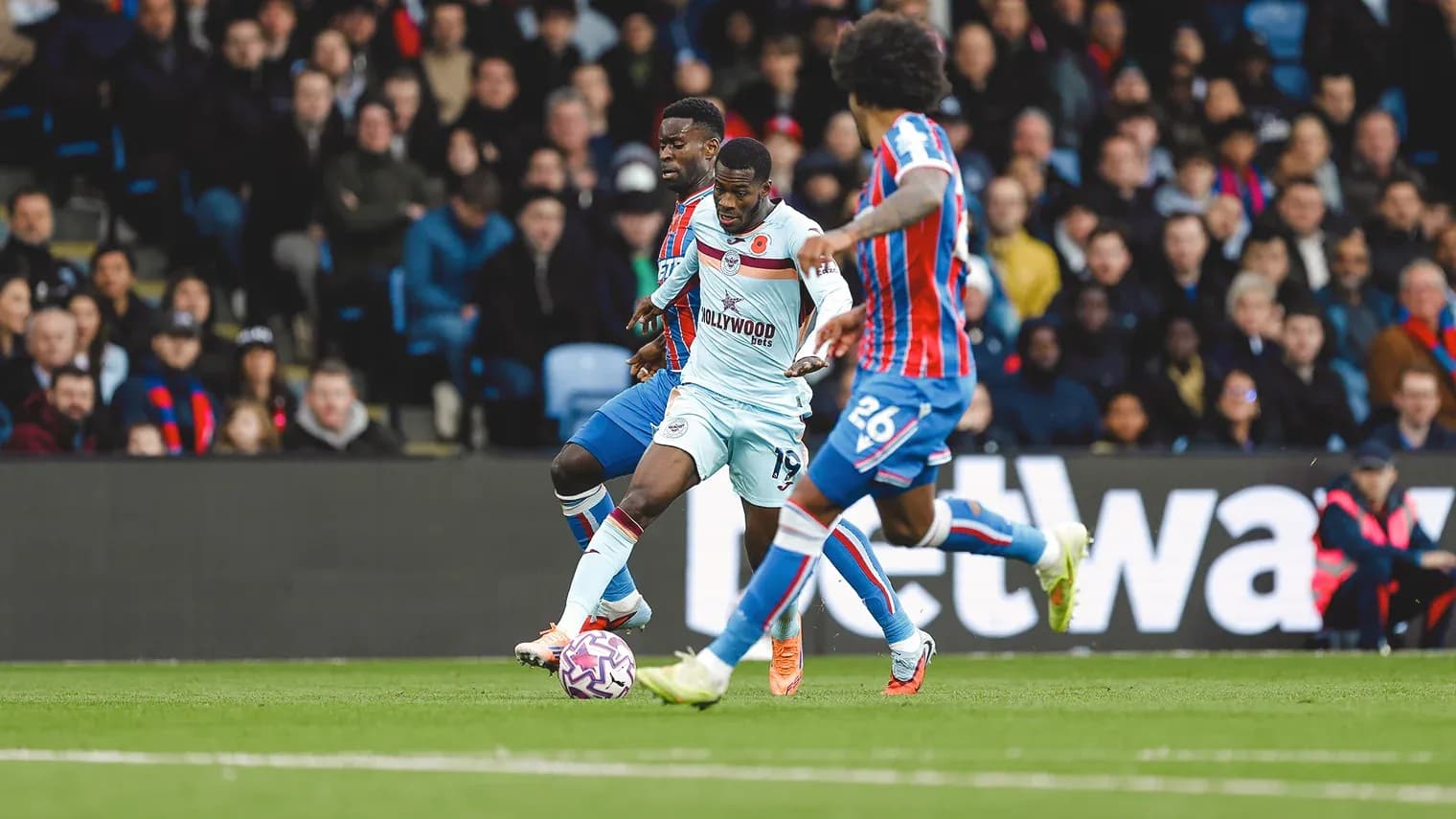 Brentford player dribbling against Crystal Palace Brentford player dribbling against Crystal Palace
