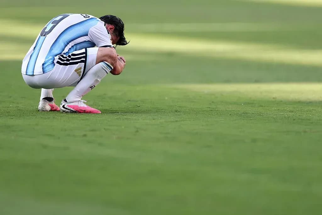 Player kneeling on pitch with head down Player kneeling on pitch with head down