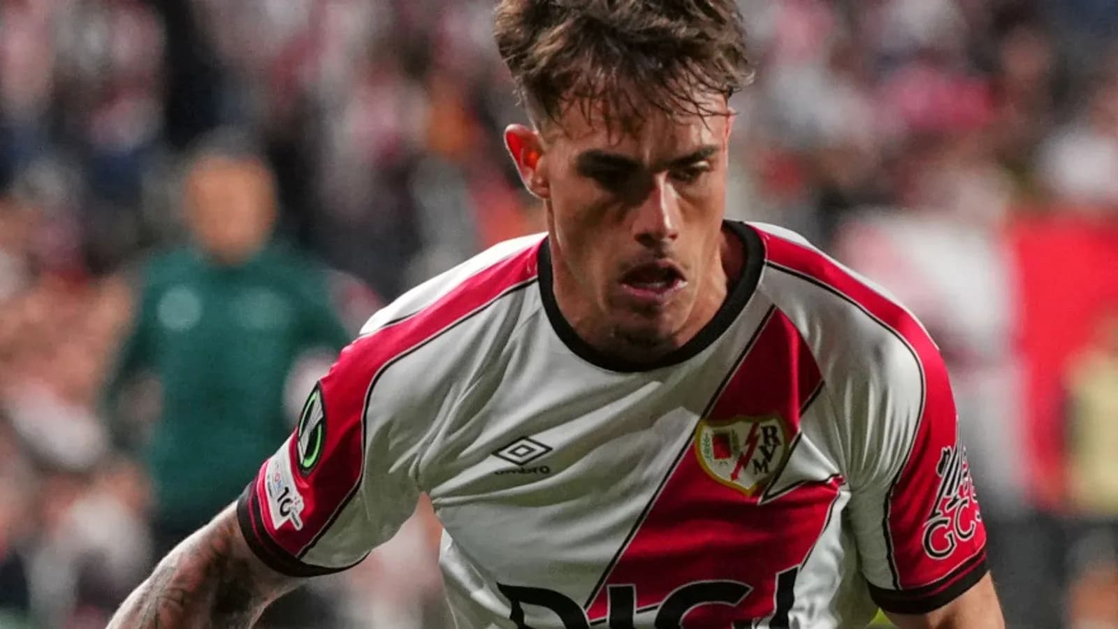 Player in Rayo Vallecano kit running during match Player in Rayo Vallecano kit running during match
