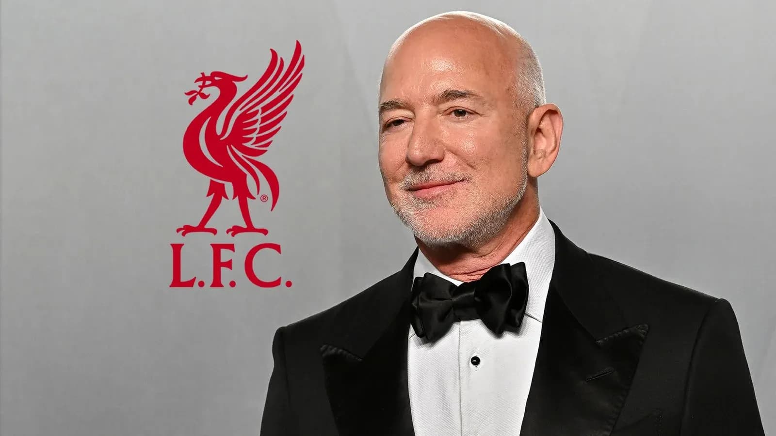Man in tuxedo with Liverpool FC logo in background Man in tuxedo with Liverpool FC logo in background