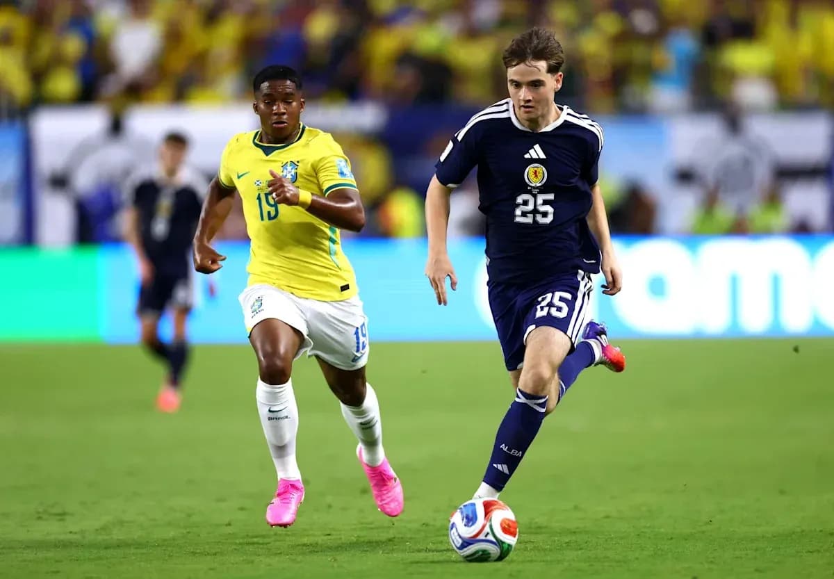 Player from Scotland dribbling past Brazilian defender Player from Scotland dribbling past Brazilian defender