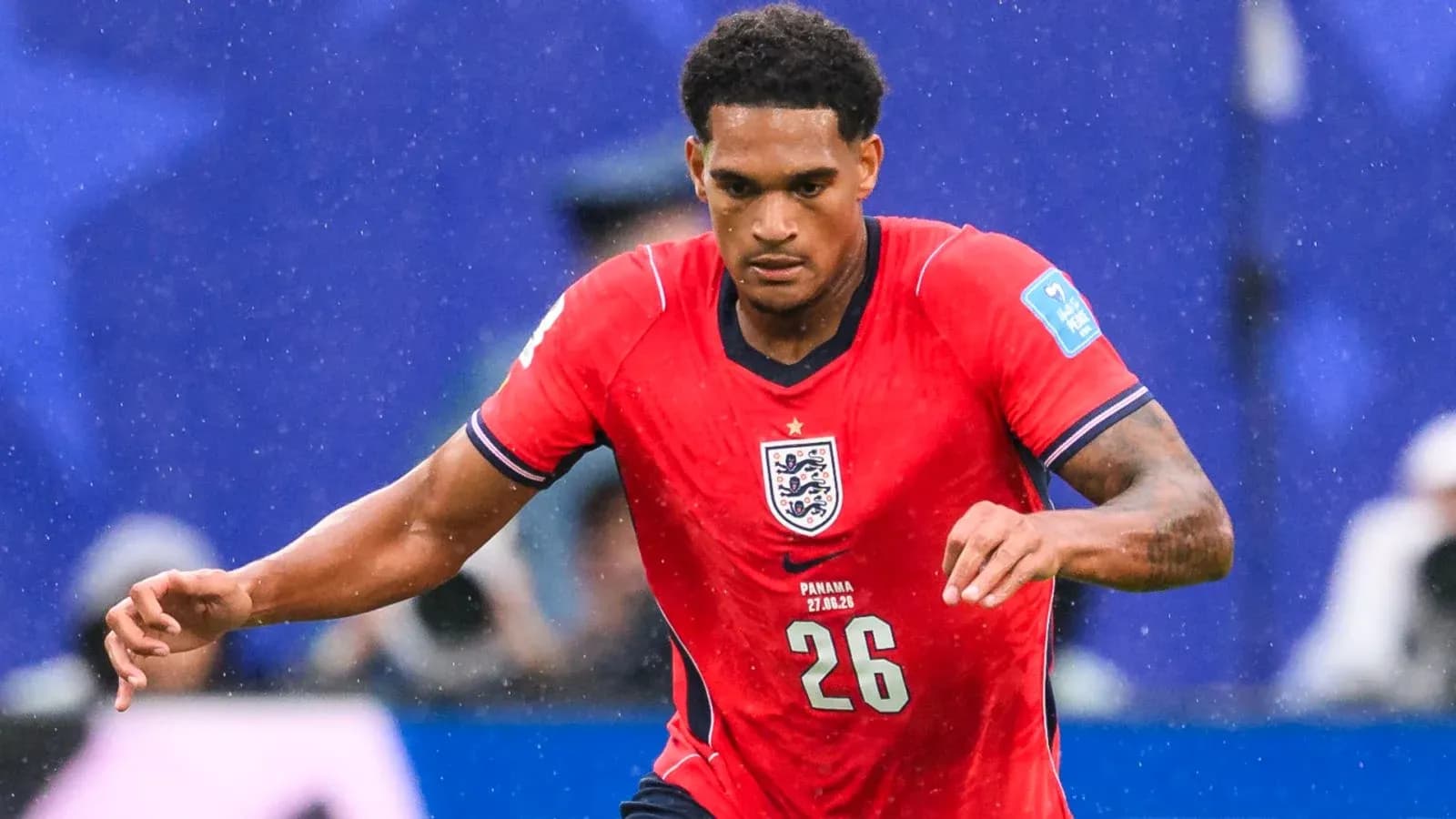 Player in red England jersey running on field Player in red England jersey running on field