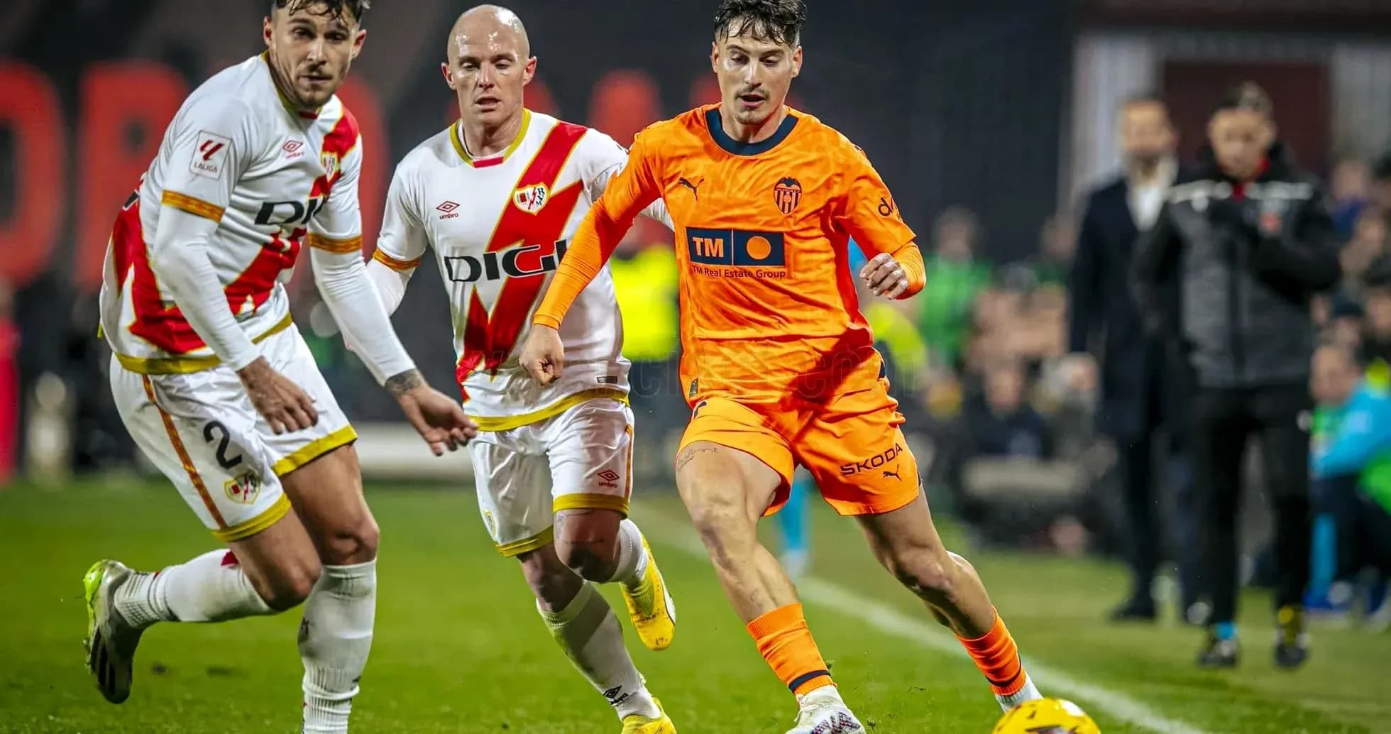 Valencia player dribbling past Rayo Vallecano defenders Valencia player dribbling past Rayo Vallecano defenders