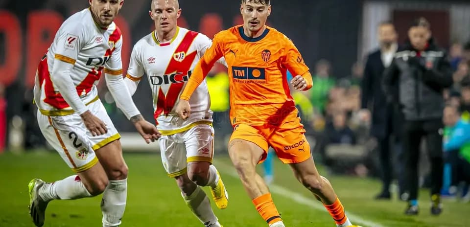 Valencia player dribbling past Rayo Vallecano defenders Valencia player dribbling past Rayo Vallecano defenders