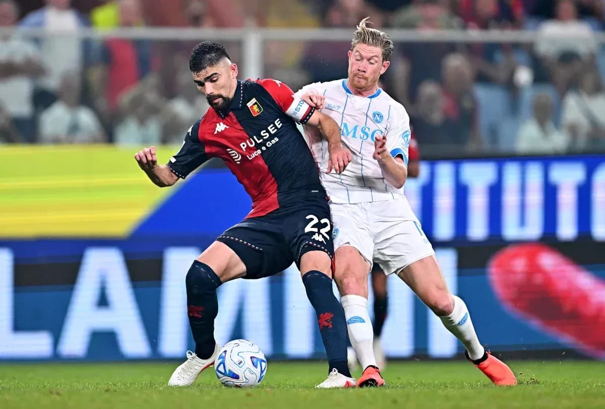 Genoa player challenged by Napoli opponent during match Genoa player challenged by Napoli opponent during match