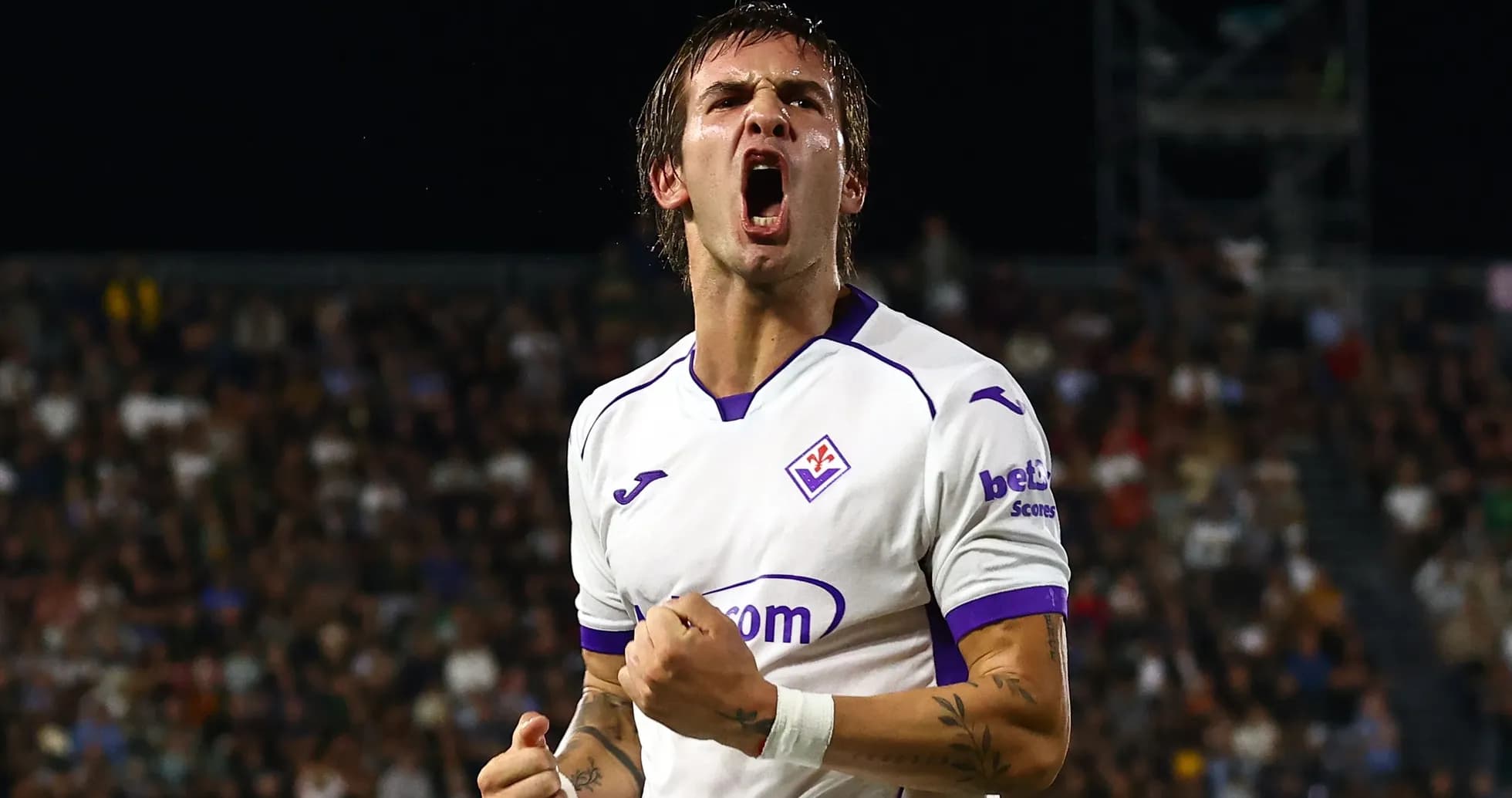 Player celebrating a goal in Fiorentina kit Player celebrating a goal in Fiorentina kit