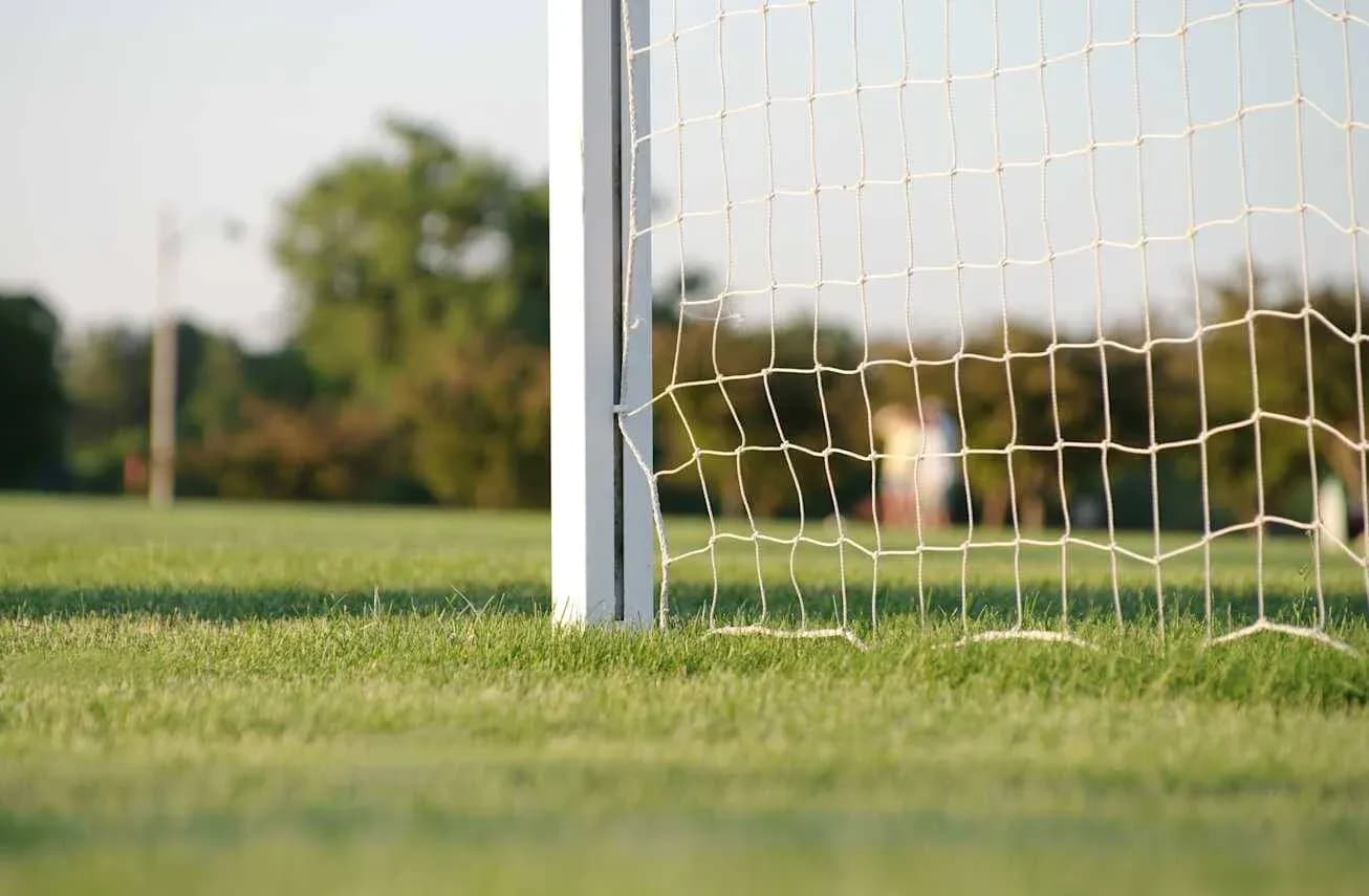 Close-up of soccer goal with netting on field Close-up of soccer goal with netting on field