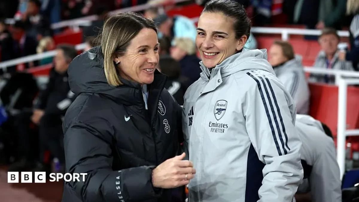 Two coaches smiling and talking on the sidelines Two coaches smiling and talking on the sidelines