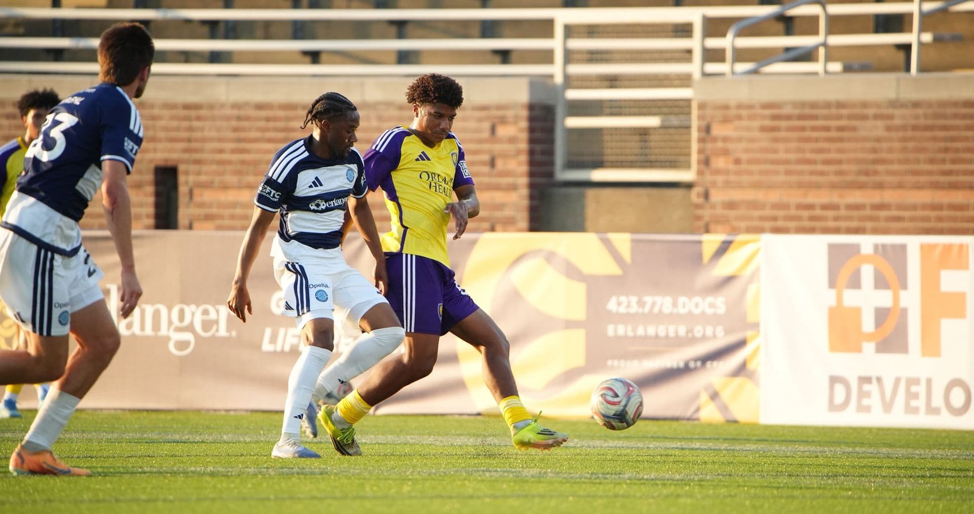 Orlando City II player tackling Chattanooga opponent Orlando City II player tackling Chattanooga opponent