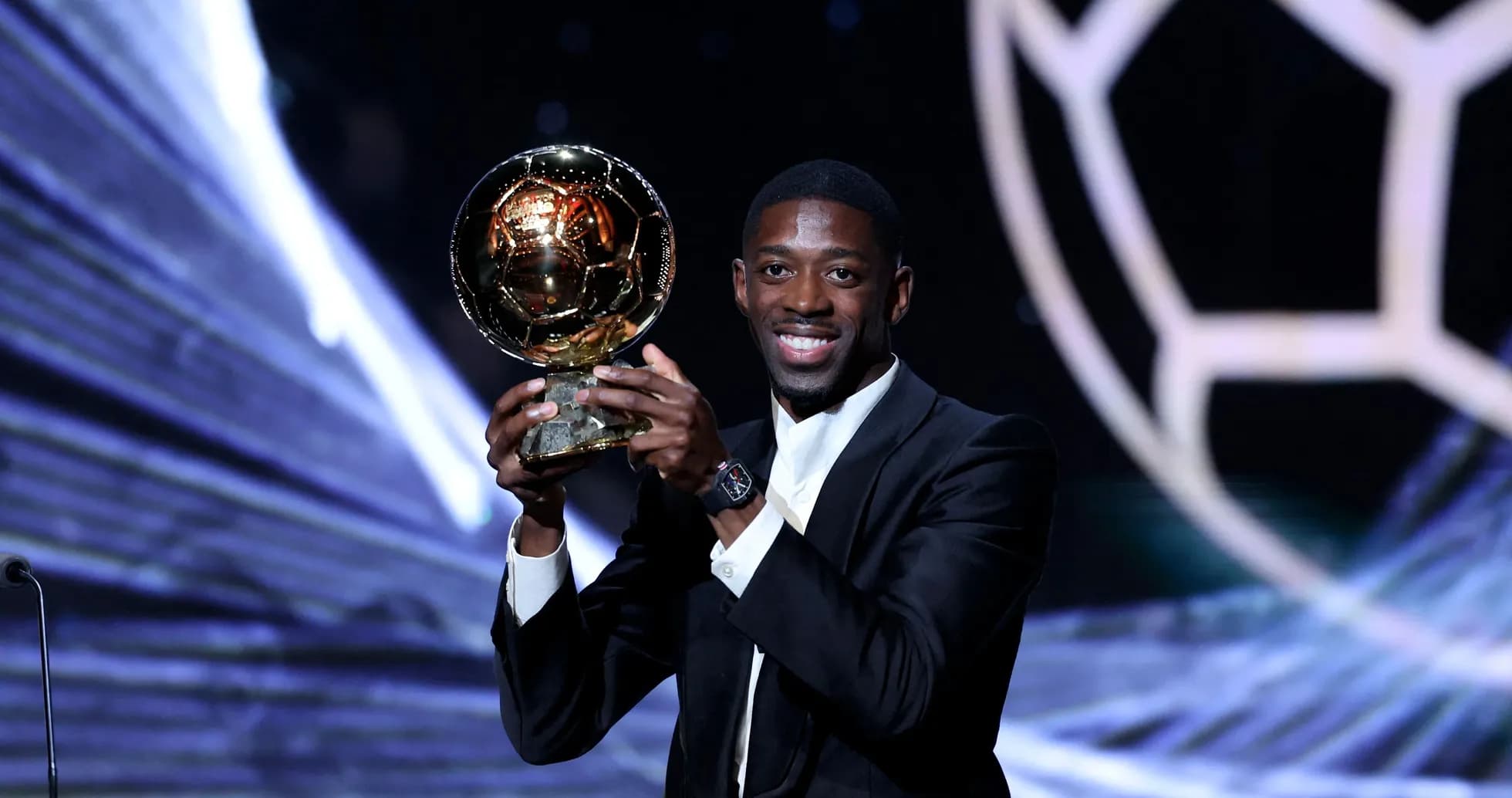 Player holding the Ballon d'Or award on stage Player holding the Ballon d'Or award on stage