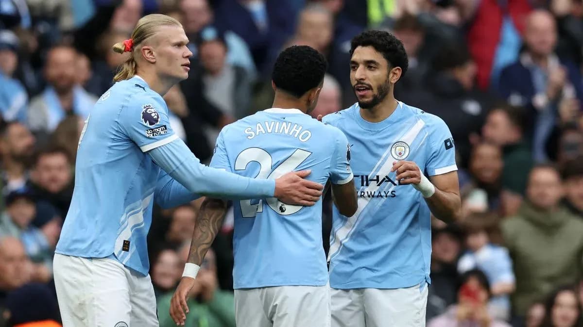 Three Manchester City players discussing on the pitch Three Manchester City players discussing on the pitch