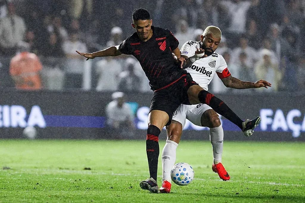 Two players battling for the ball in rain Two players battling for the ball in rain