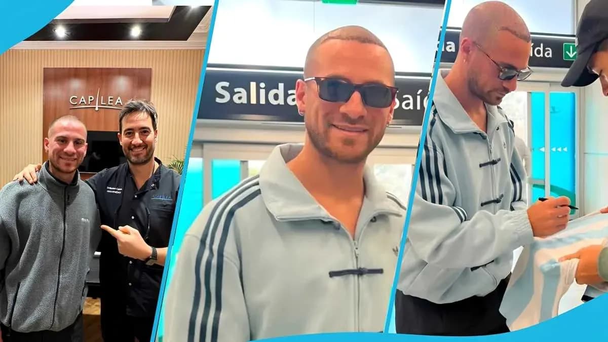 Two men posing together, one signing a shirt Two men posing together, one signing a shirt