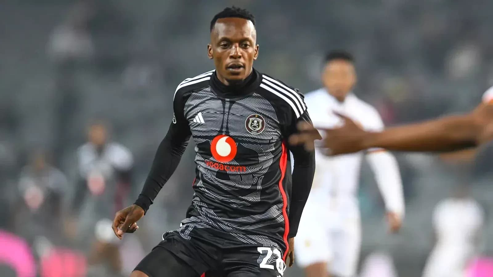 Player in black kit running on the field Player in black kit running on the field