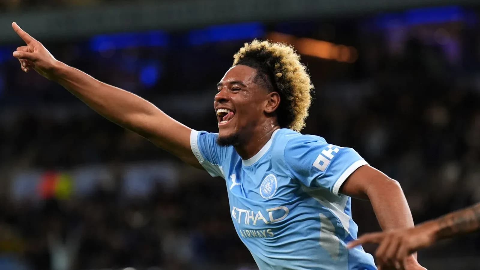 Player celebrating goal with raised hand in match Player celebrating goal with raised hand in match
