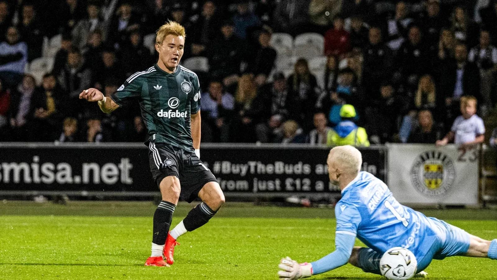 Player attempting to score as goalkeeper dives Player attempting to score as goalkeeper dives