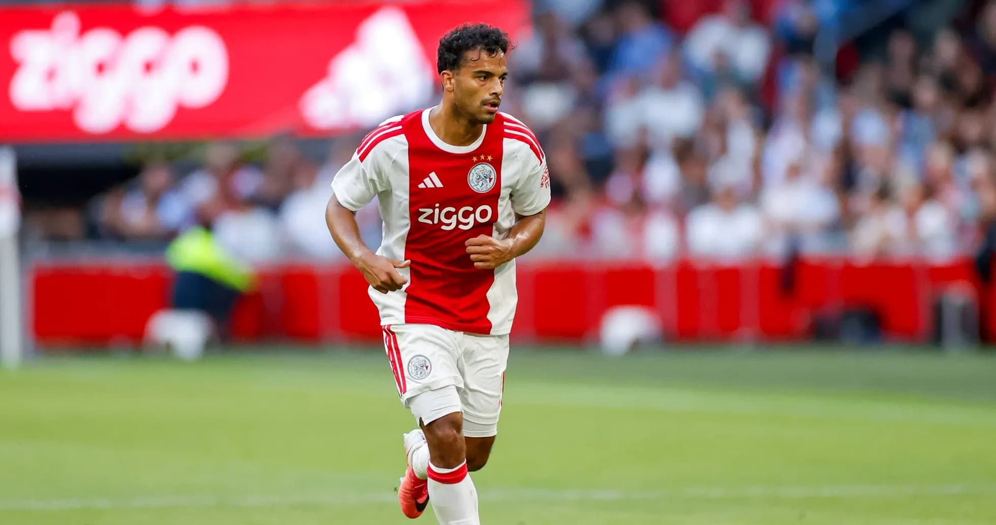 Player in Ajax kit running on the pitch Player in Ajax kit running on the pitch
