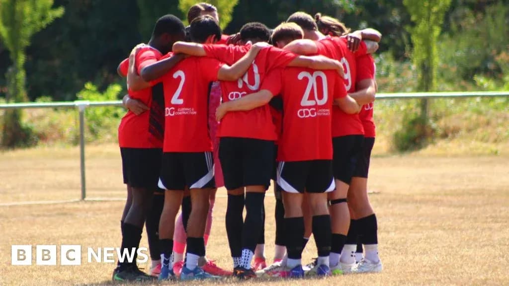 Team huddled together on training field Team huddled together on training field