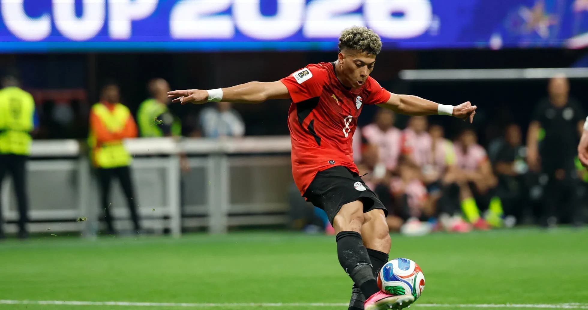 Player in red jersey kicking soccer ball during match Player in red jersey kicking soccer ball during match
