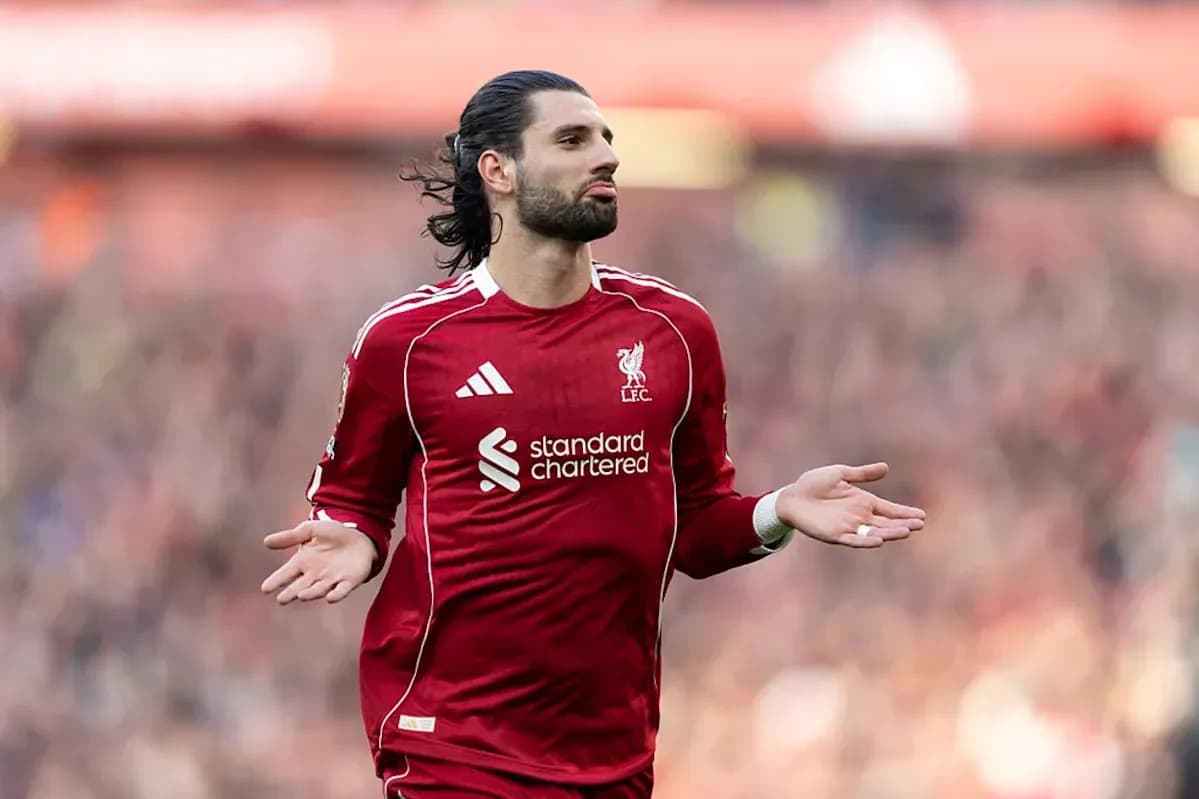 Player in red Liverpool kit gesturing on the pitch Player in red Liverpool kit gesturing on the pitch
