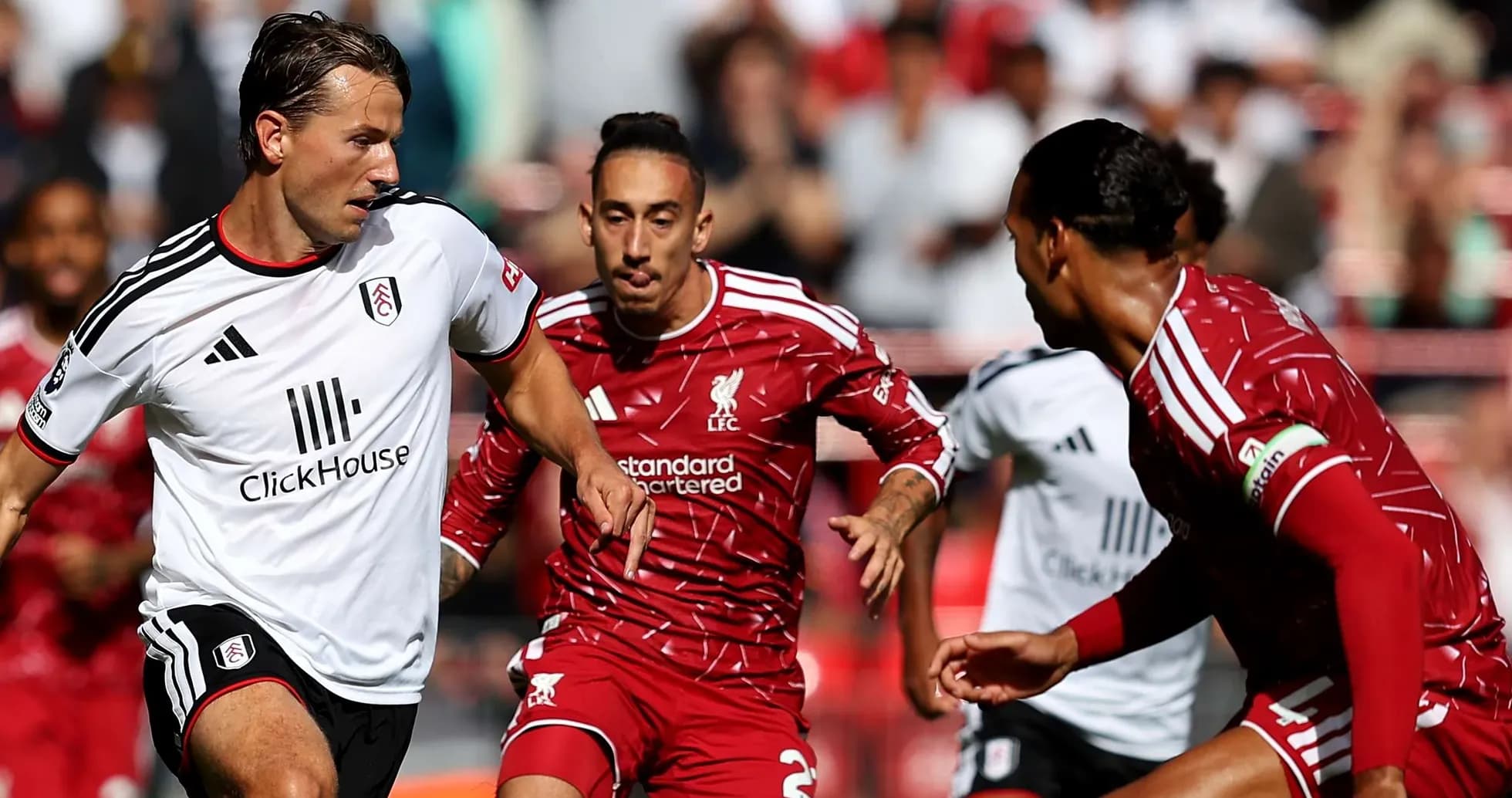 Liverpool players challenging Fulham opponent for the ball Liverpool players challenging Fulham opponent for the ball