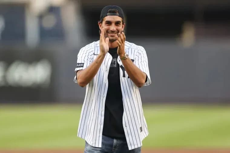 Man in Yankees jersey applauding on baseball field Man in Yankees jersey applauding on baseball field