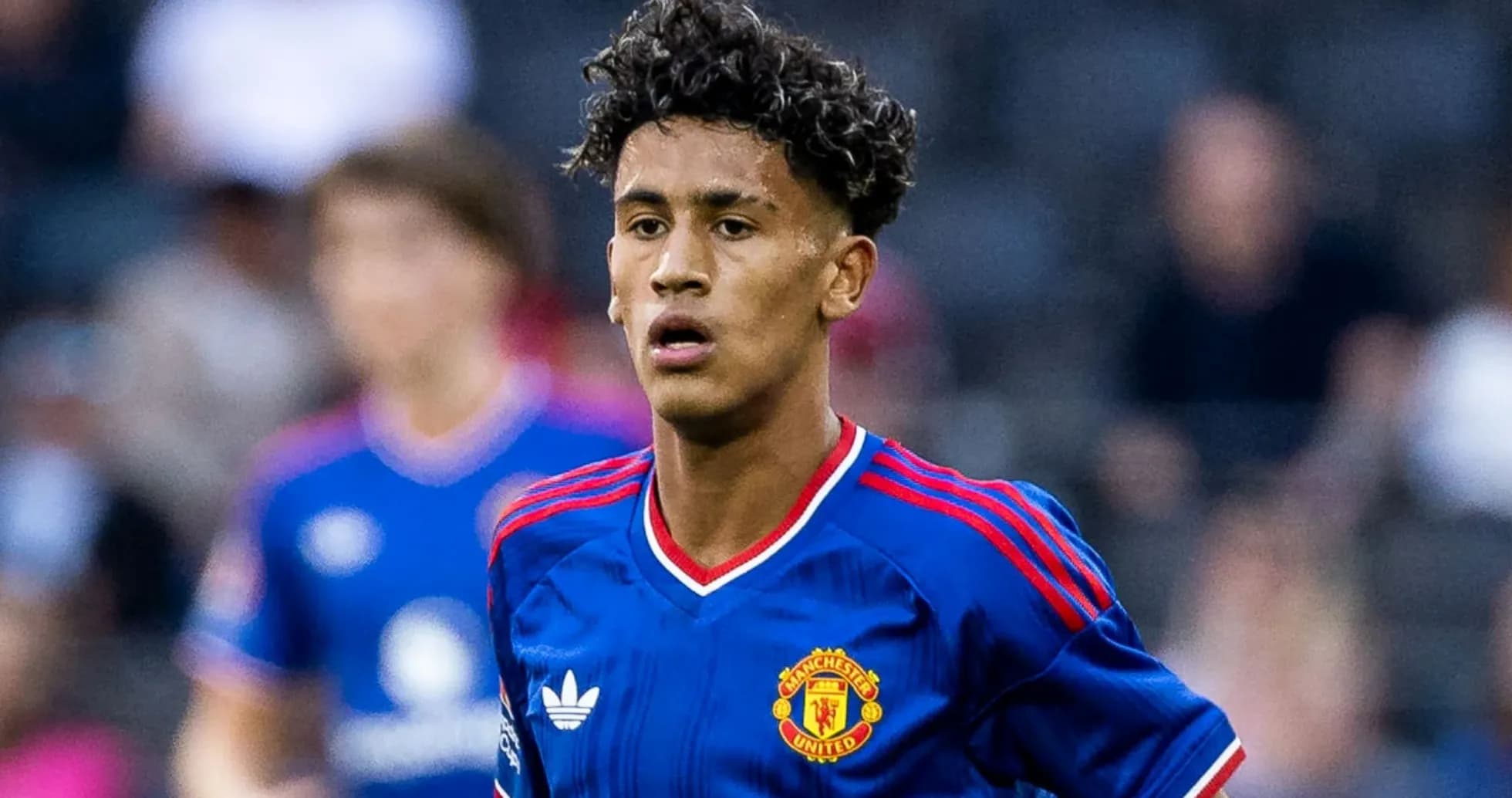 Young player wearing Manchester United kit on pitch Young player wearing Manchester United kit on pitch