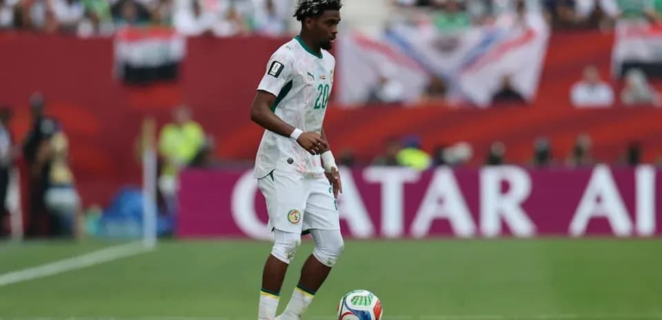 Player in Senegal kit controlling the ball on field Player in Senegal kit controlling the ball on field