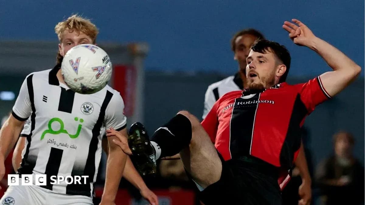 Player kicking ball during competitive match action Player kicking ball during competitive match action