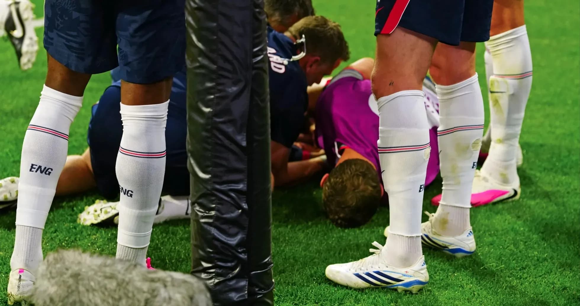 Players gathered around an injured teammate on field Players gathered around an injured teammate on field