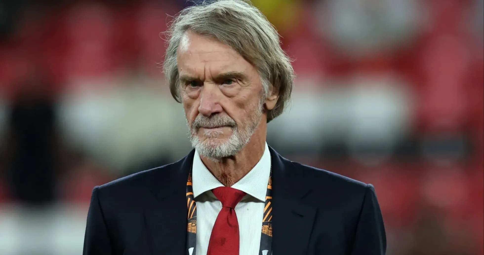 Man in suit with a red tie at stadium Man in suit with a red tie at stadium