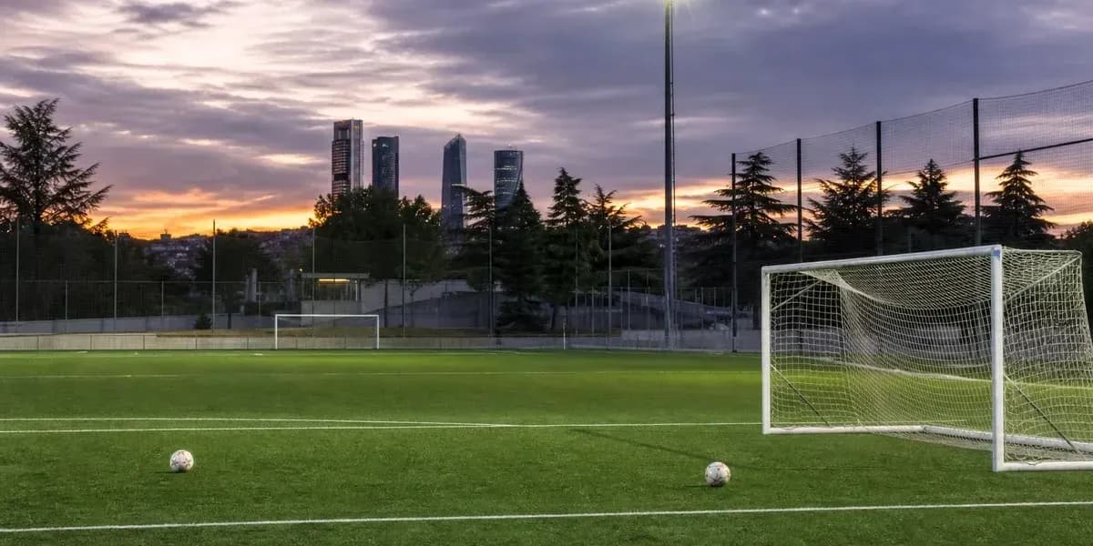 Soccer field with goal and two balls at sunset Soccer field with goal and two balls at sunset