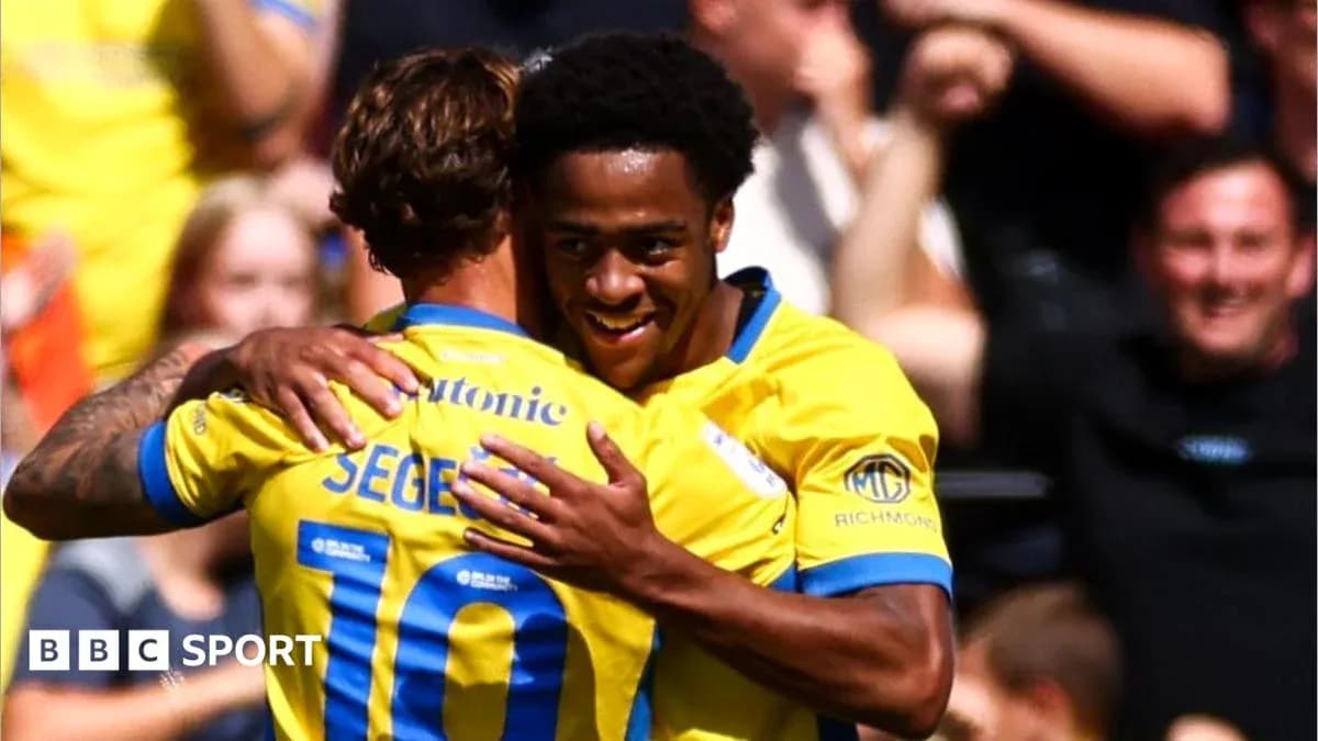 Players celebrating a goal with a hug Players celebrating a goal with a hug