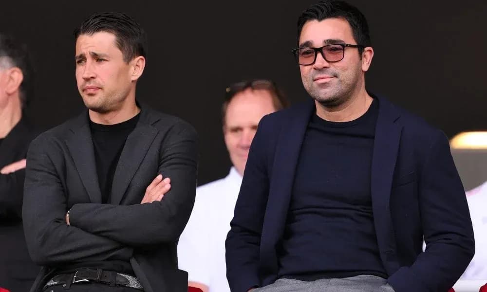 Two men sitting in stands during a match Two men sitting in stands during a match