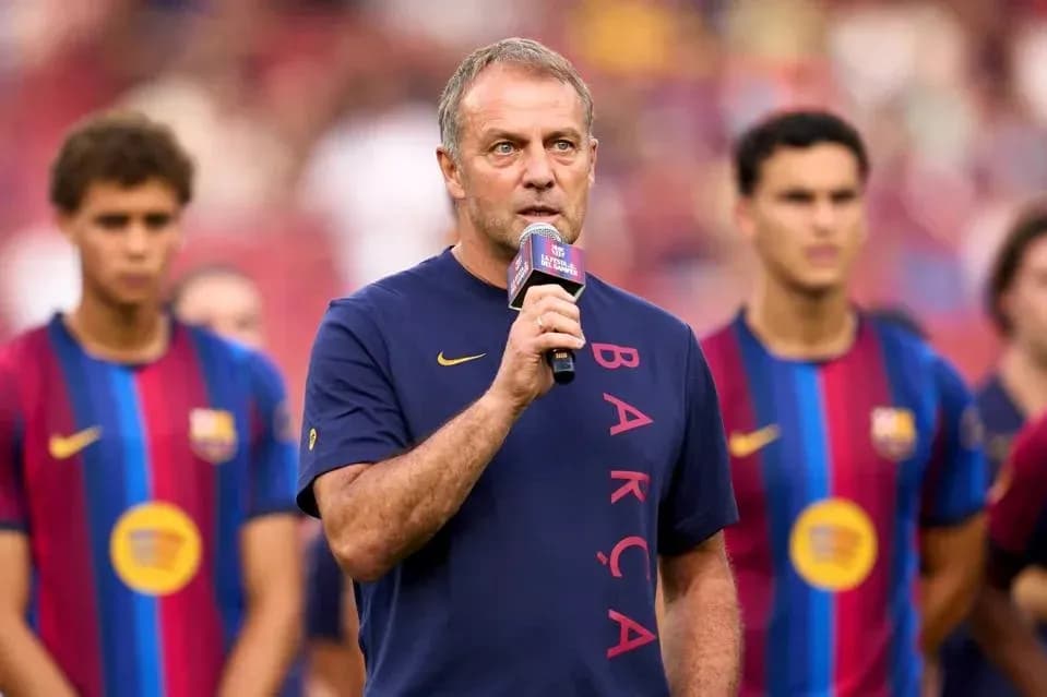 Coach speaking at event with players in background Coach speaking at event with players in background