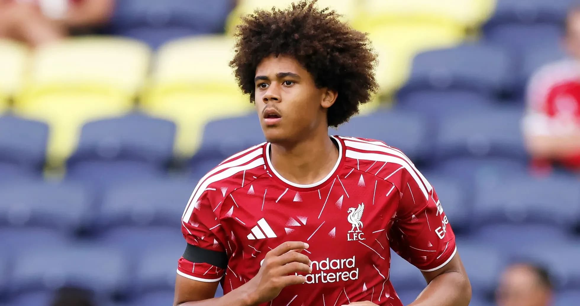 Player in Liverpool kit warming up on pitch Player in Liverpool kit warming up on pitch