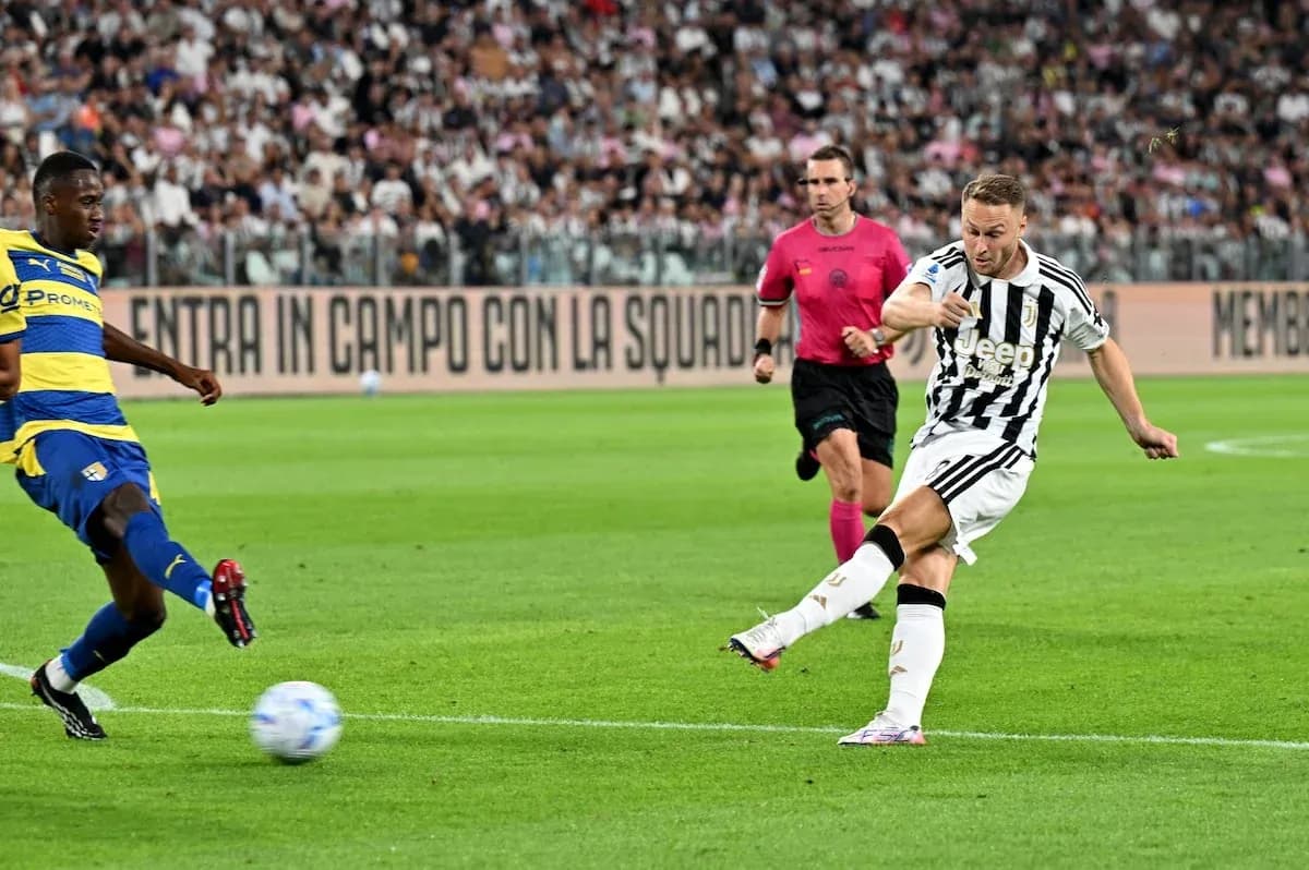 Juventus player shooting against Parma defender Juventus player shooting against Parma defender