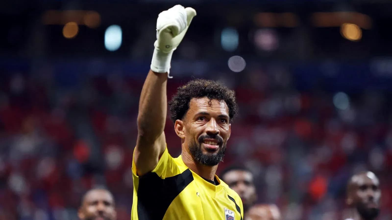 Goalkeeper celebrating with raised hand after match Goalkeeper celebrating with raised hand after match