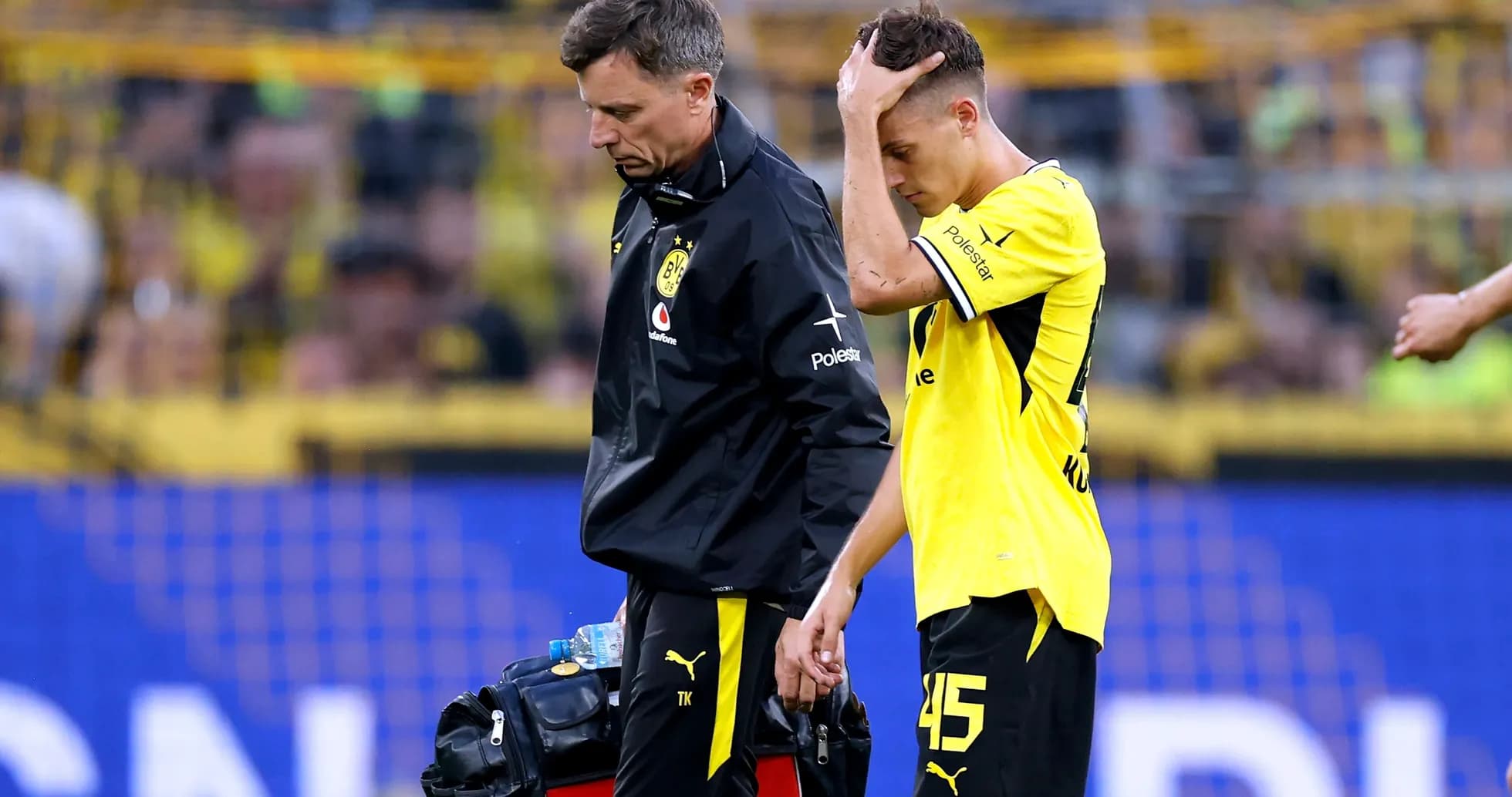 Player receiving assistance from medical staff after injury Player receiving assistance from medical staff after injury