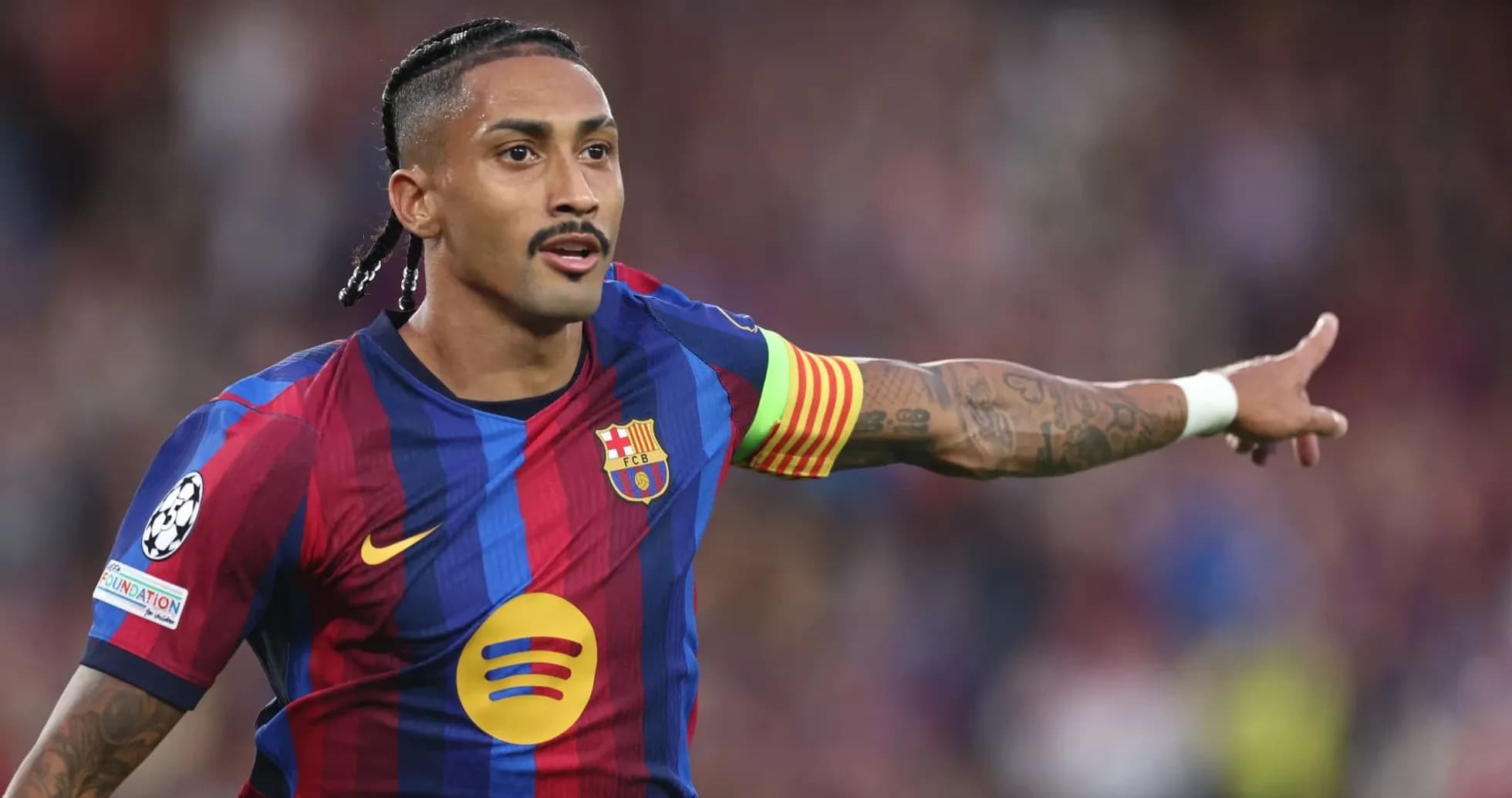 Player in FC Barcelona kit directing teammates on field Player in FC Barcelona kit directing teammates on field