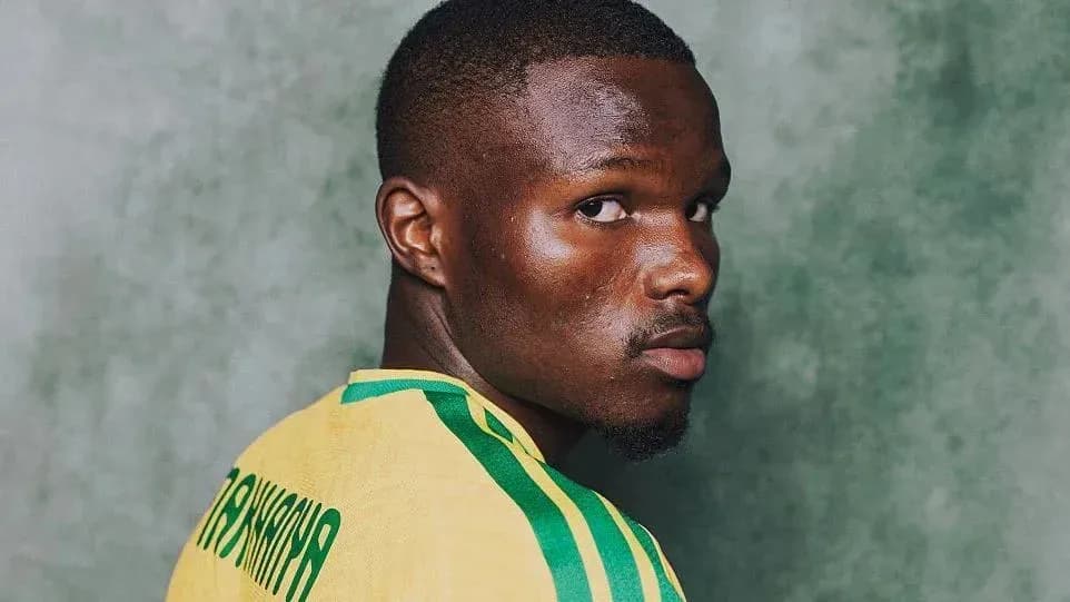 Player posing in yellow jersey with green stripes Player posing in yellow jersey with green stripes